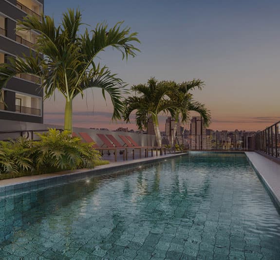 Piscina externa com espreguiçadeiras e vista para a cidade